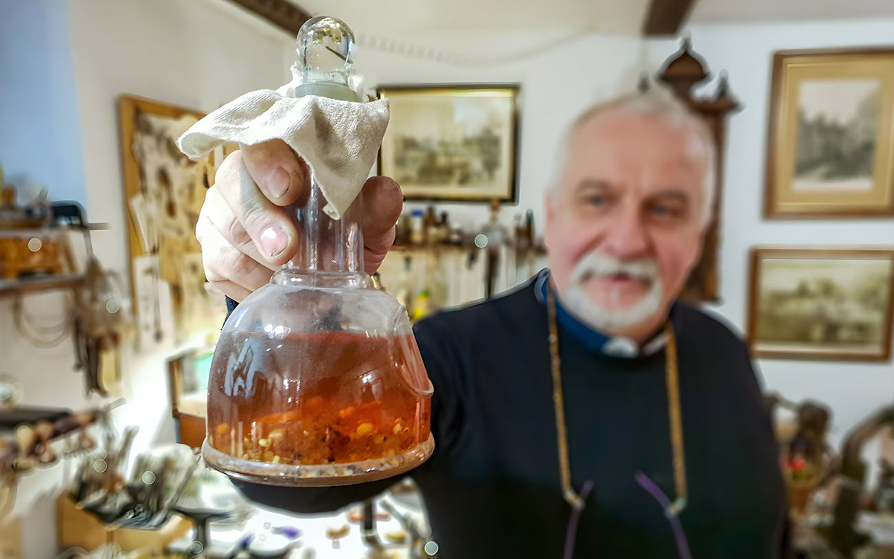 Man holding amber-filled flask at Gdańsk Amber Workshop.