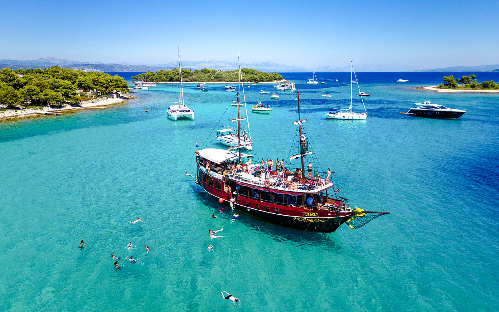 Tourists swimming near a boat in Blue Lagoon, Croatia.