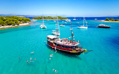 Tourists swimming near a boat in Blue Lagoon, Croatia.