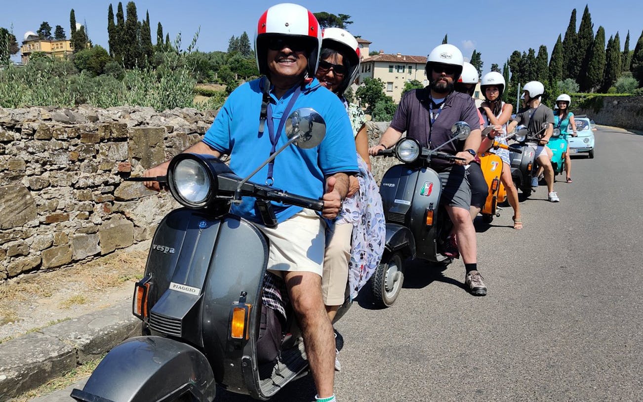Group riding Vespas on a guided tour through Tuscany countryside from Florence.