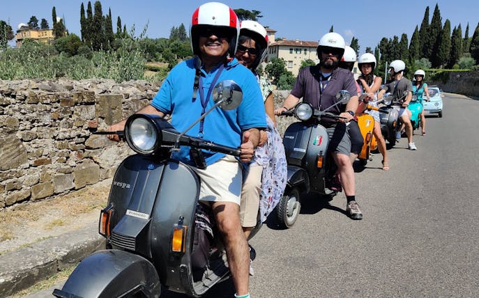 Group riding Vespas on a guided tour through Tuscany countryside from Florence.