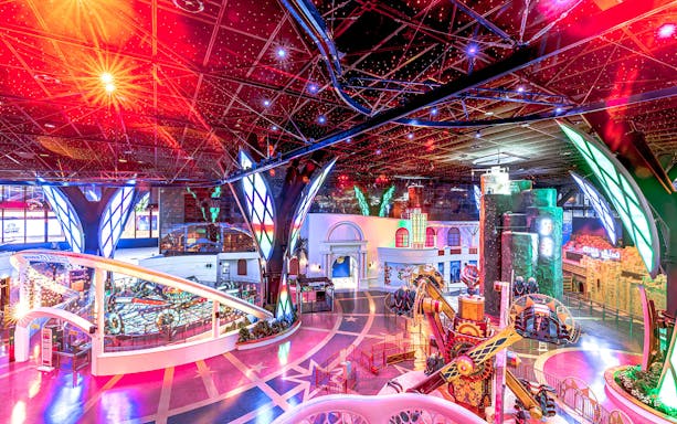 Doha Quest Theme Park indoor roller coaster with vibrant lights and futuristic design.
