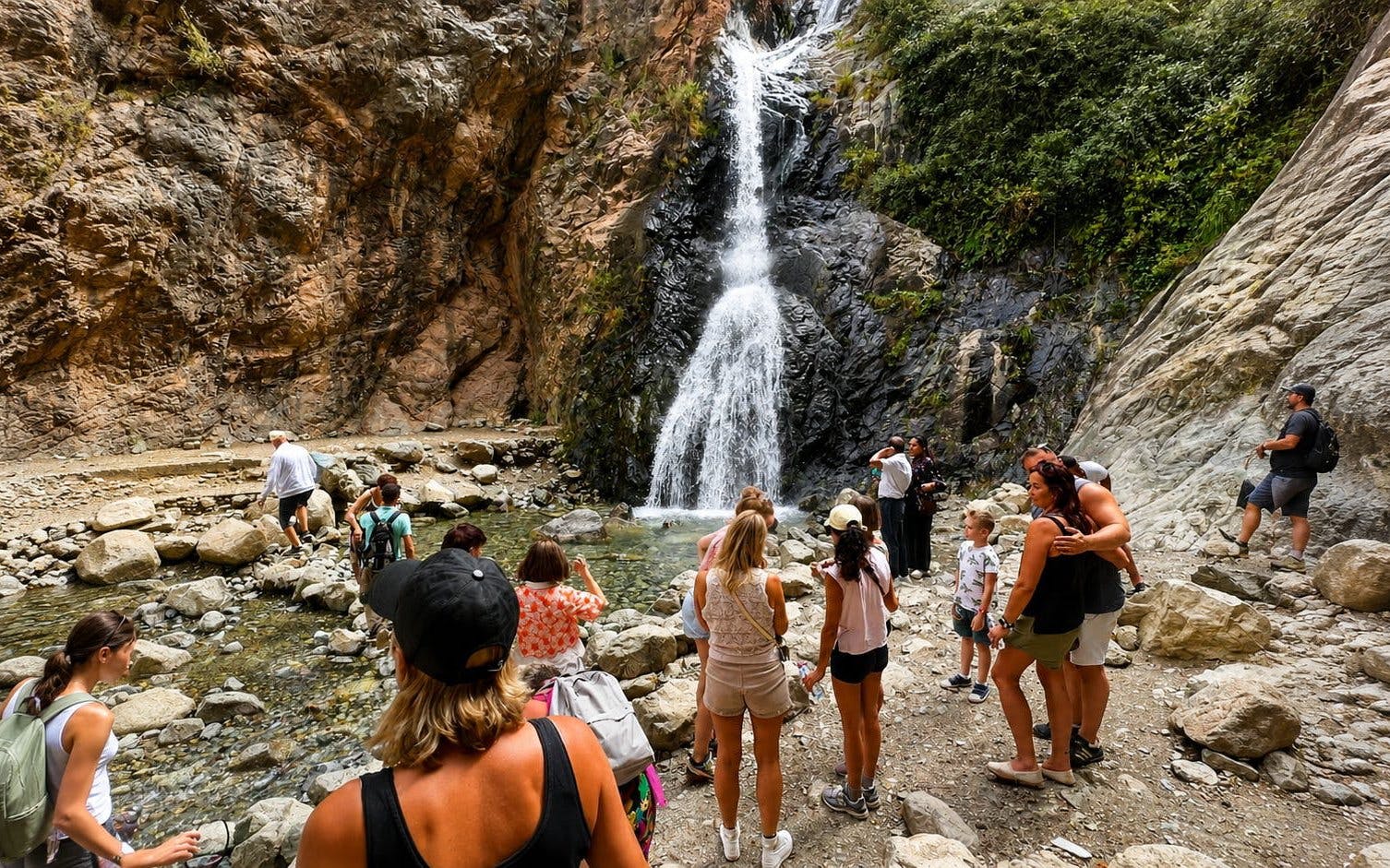 Tourists exploring waterfall in Ourika Valley, Atlas Mountains, Marrakech.