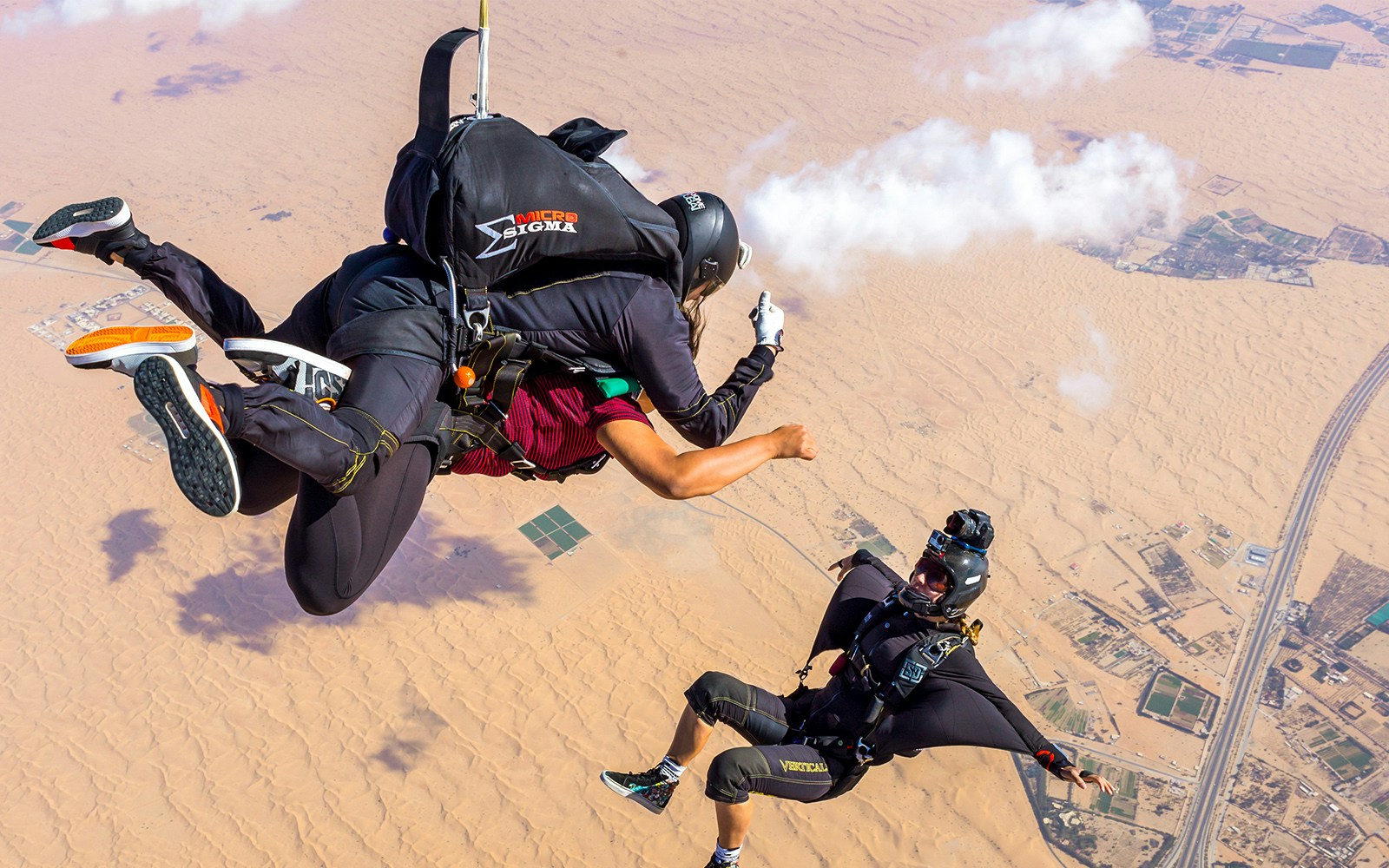 Tourist Sky diving over Desert Drop Zone and posing for Camerman