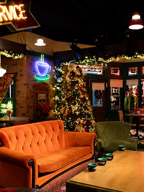 Central Perk set with orange couch and holiday decorations at The FRIENDS™ Experience.
