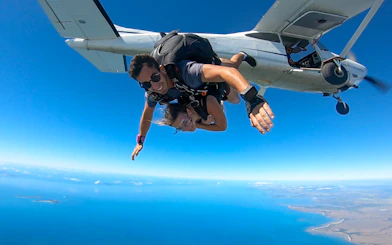 Tandem skydive over Airlie Beach with ocean view and beach landing.