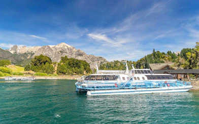 Excursion boat docking at Puerto Blest on Nahuel Huapi Lake with mountains in the background.