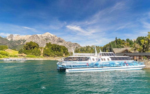 Excursion boat docking at Puerto Blest on Nahuel Huapi Lake with mountains in the background.