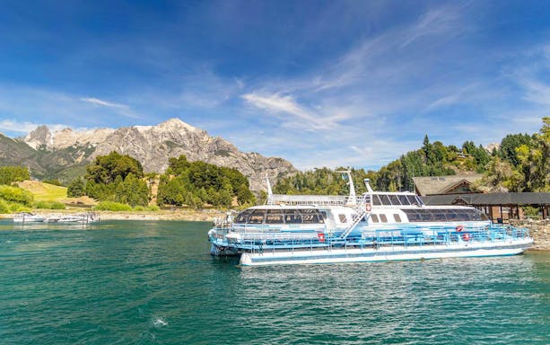 Excursion boat docking at Puerto Blest on Nahuel Huapi Lake with mountains in the background.