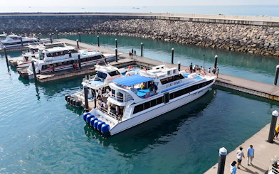 Boats docked at the pier near Nusa Penida with passengers boarding.