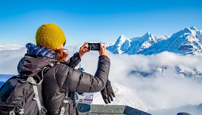Tourist taking pictures of snow capped mountain - Grindelwald in Feburary
