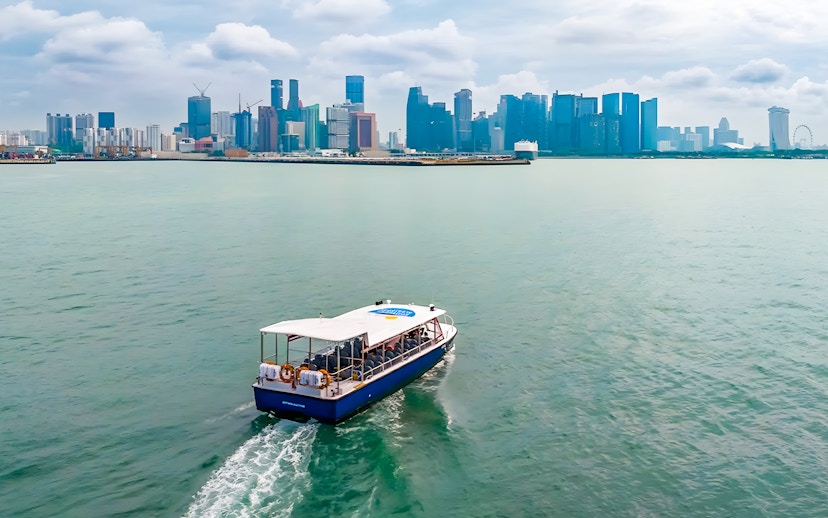 Boat cruising towards city skyline across the water.