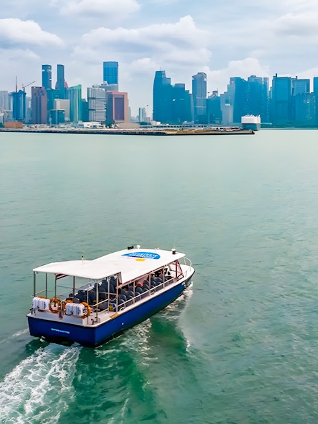 Boat cruising towards city skyline across the water.