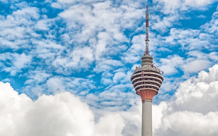 KL Tower Sky Deck against a cloudy blue sky in Kuala Lumpur.