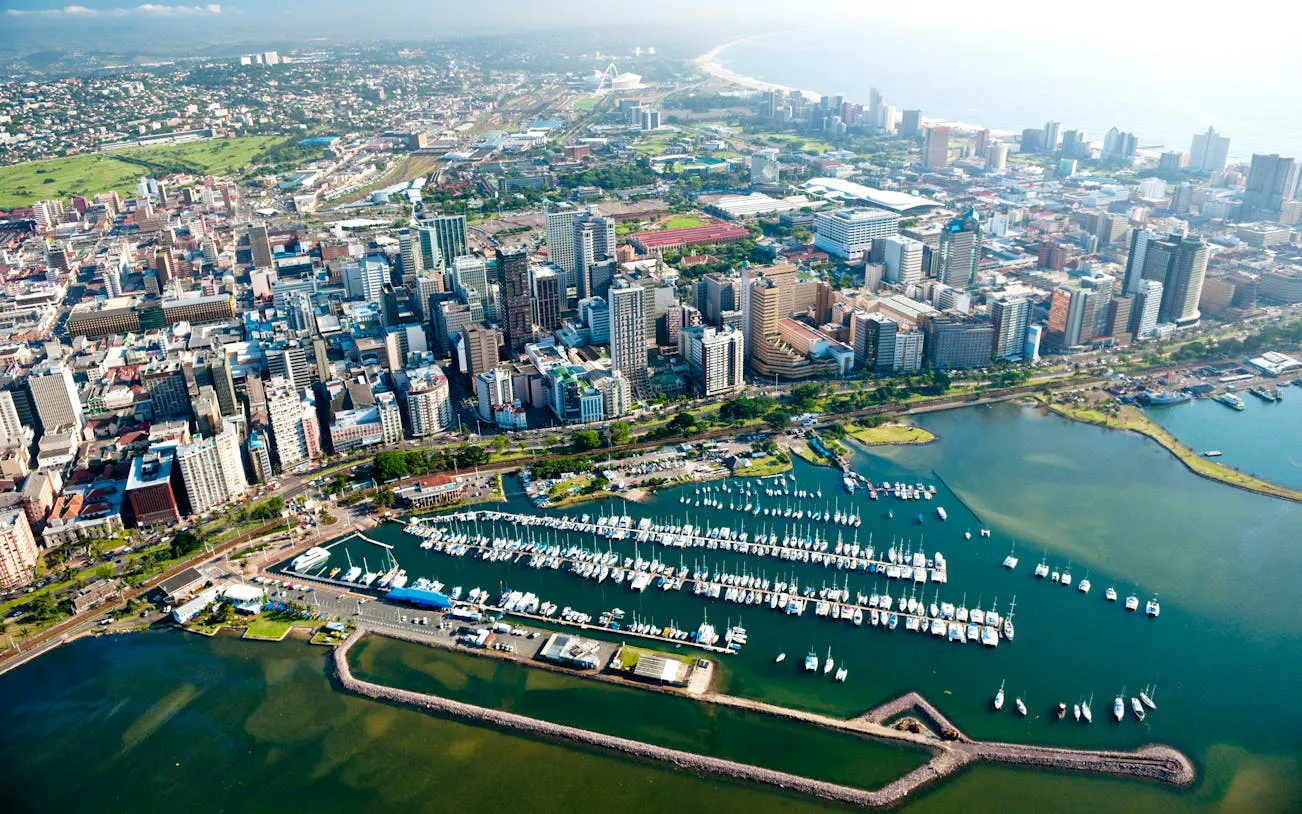 Aerial view of Durban cityscape with marina and coastline, South Africa.