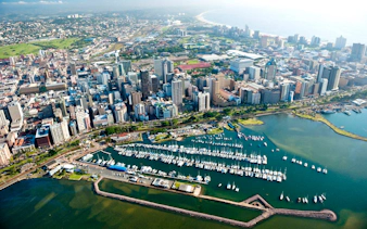 Aerial view of Durban cityscape with marina and coastline, South Africa.