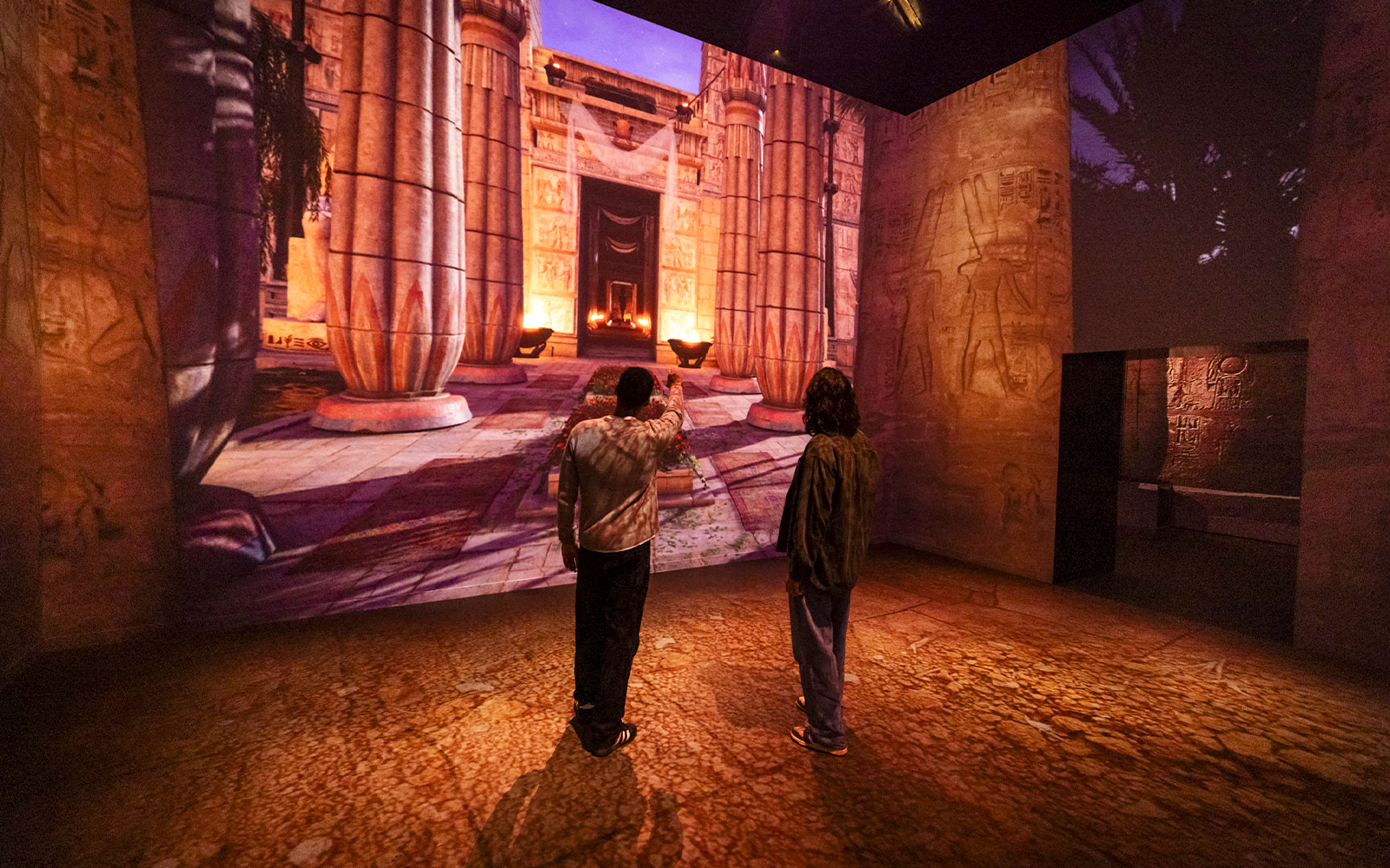 Visitors viewing ancient Egyptian temple projection at Fabrique des Lumières exhibition.