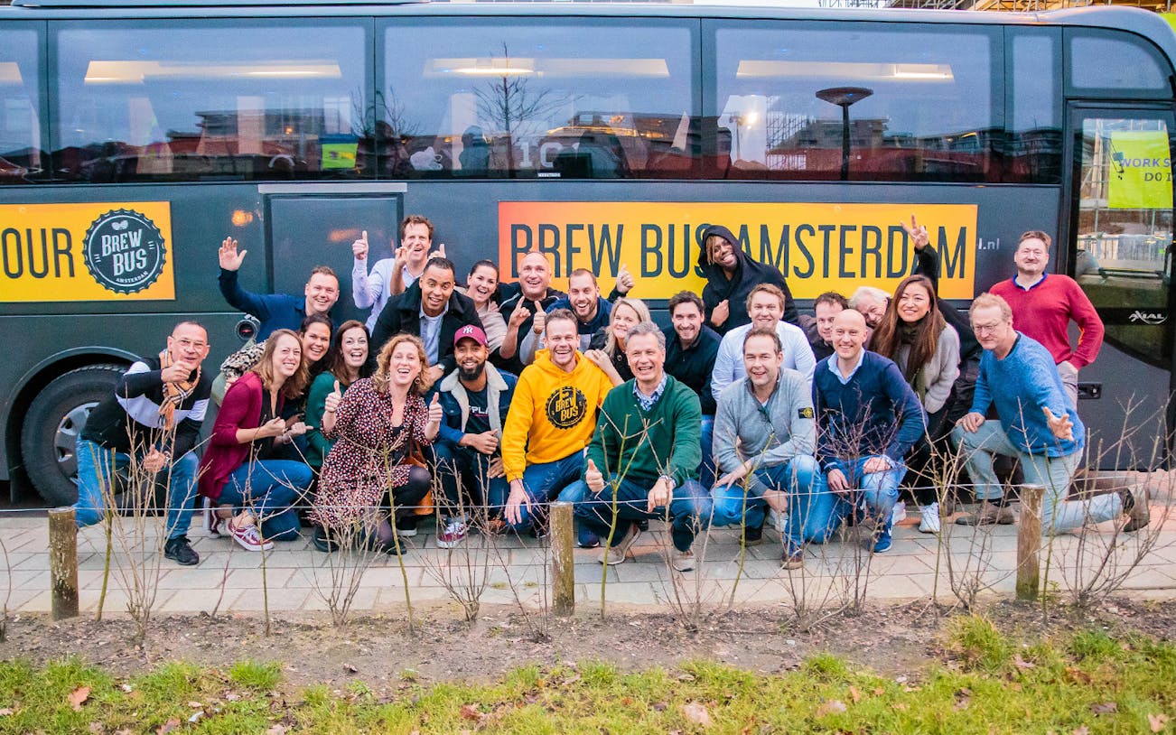 Group of people posing in front of Brew Bus Amsterdam for a craft beer and brewery tour.