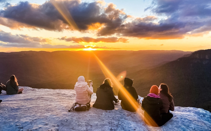 Tourists enjoying sunset views over Jamison Valley on Blue Mountains day trip from Sydney.