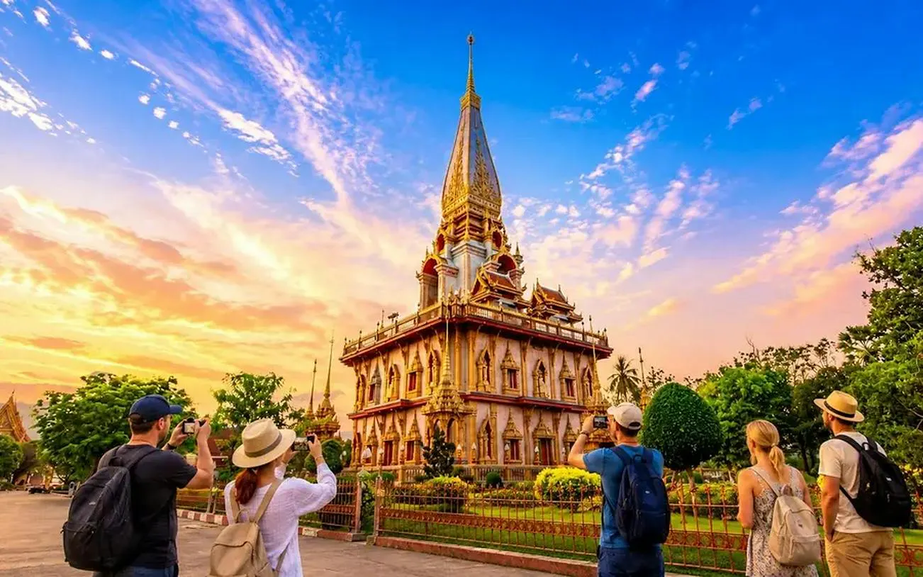 Wat Chalong temple at sunset with tourists taking photos, Phuket.