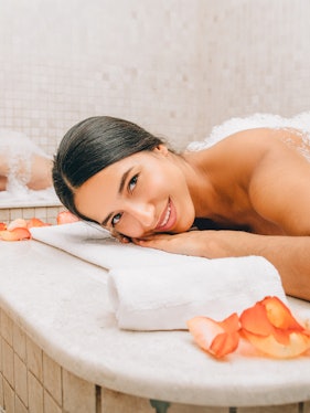 Woman enjoying a traditional Turkish bath with rose petals in Istanbul.