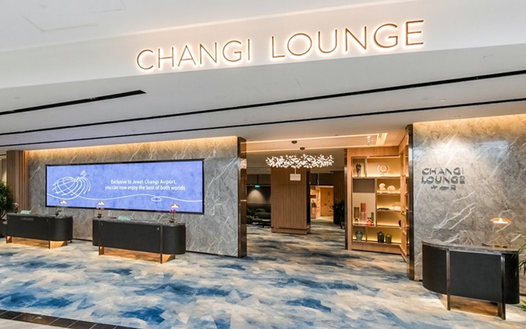 Entrance to Changi Lounge at Singapore Airport with modern decor and reception desks.