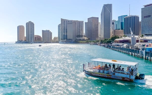 Cruise boat on Miami waters with downtown skyline in the background.