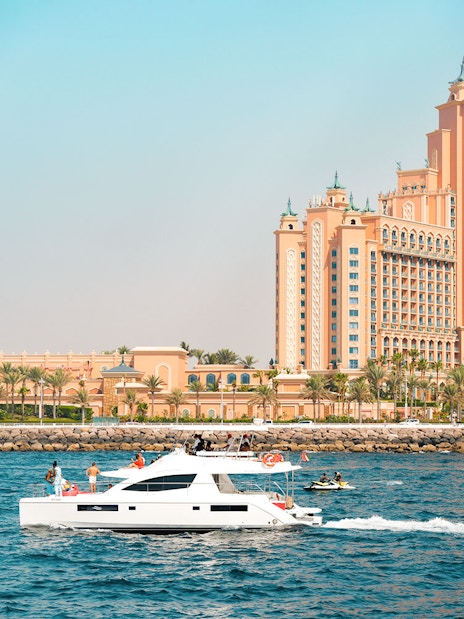 Luxury yacht cruising past Atlantis The Palm, Dubai.