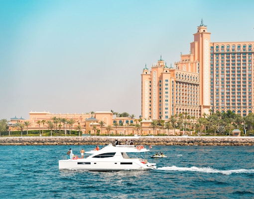 Luxury yacht cruising past Atlantis The Palm, Dubai.