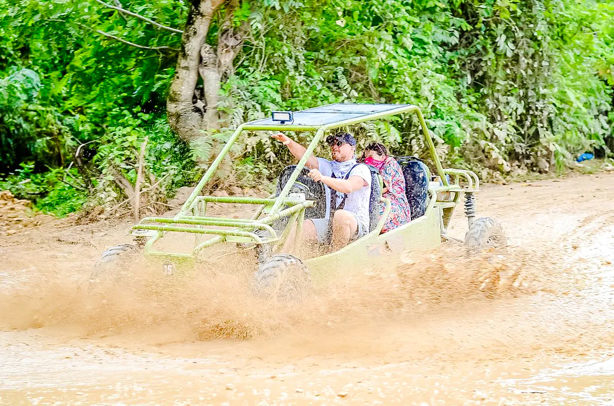 ATV driving through mud in Punta Cana jungle during adventure tour.