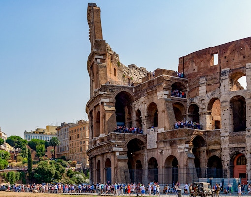 Colosseum in Rome with tourists exploring the ancient amphitheater.