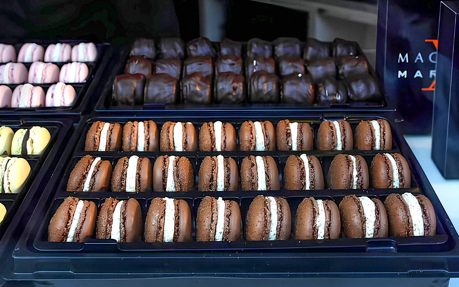 Assorted macarons displayed in trays during the Arc de Triomphe walking tour in Paris.