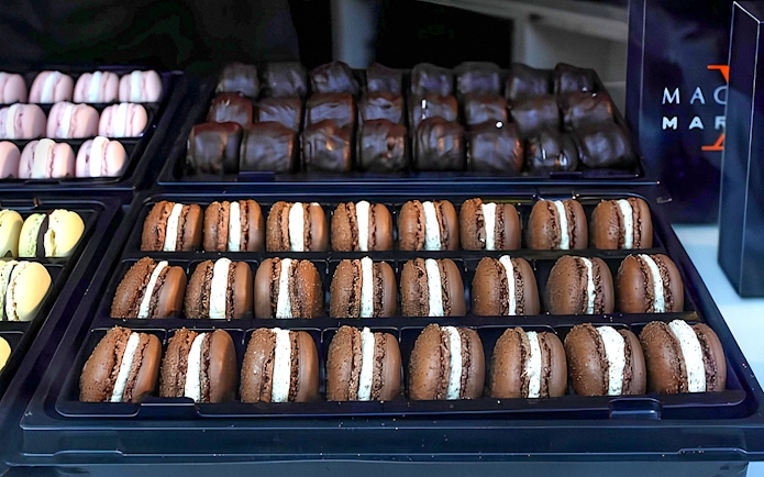 Assorted macarons displayed in trays during the Arc de Triomphe walking tour in Paris.