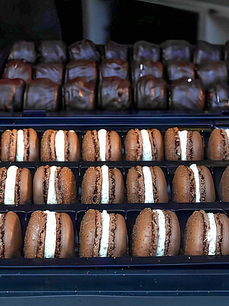 Assorted macarons displayed in trays during the Arc de Triomphe walking tour in Paris.