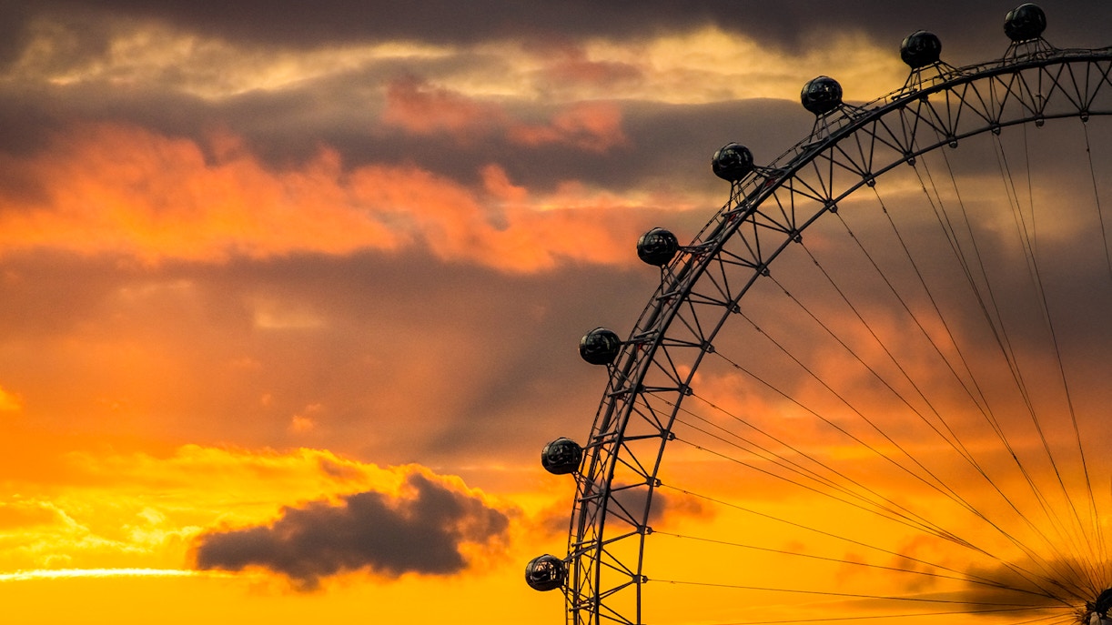 London Eye silhouetted against a vibrant sunset sky.