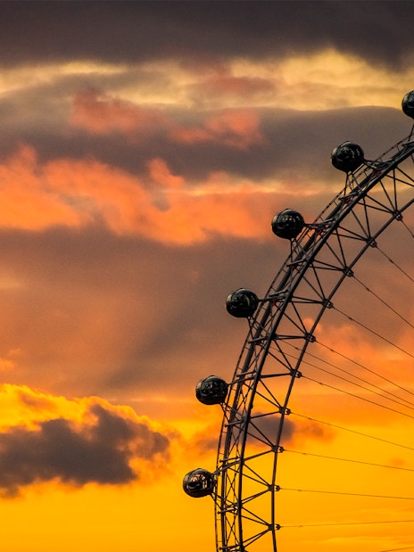 London Eye silhouetted against a vibrant sunset sky.