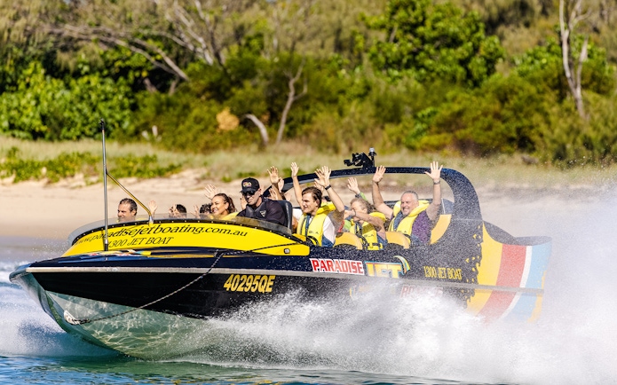 Jet boat with passengers enjoying a thrilling ride on Gold Coast waters.