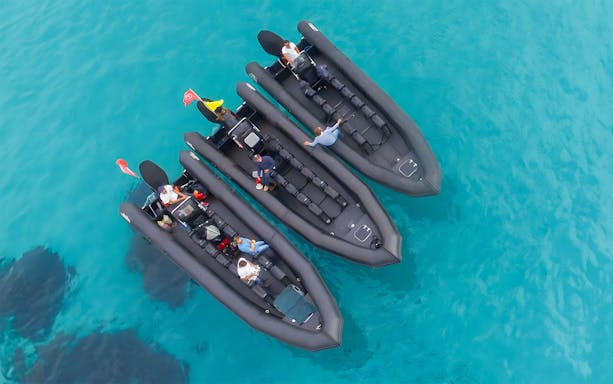 Three inflatable boats with passengers on clear blue water near St Jean Cap Ferrat.