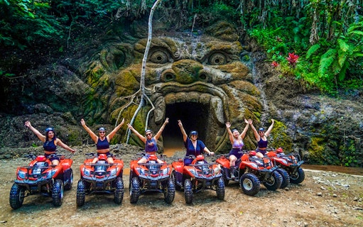 ATV riders in front of Gorilla Face cave entrance in Ubud jungle.