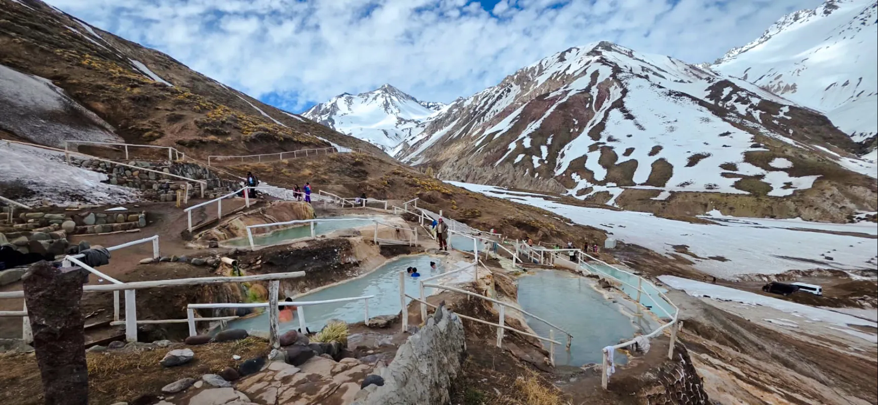 Hot springs at Termas Baños Colina with snow-capped Andes in Cajon del Maipo, Santiago.