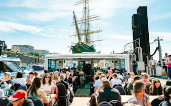 Guests enjoying sightseeing on a boat during the 2-Hour XXL Port of Hamburg Cruise Tour.