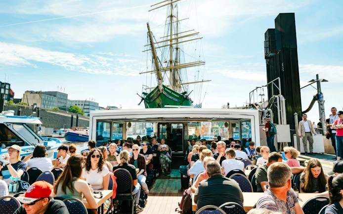 Guests enjoying sightseeing on a boat during the 2-Hour XXL Port of Hamburg Cruise Tour.