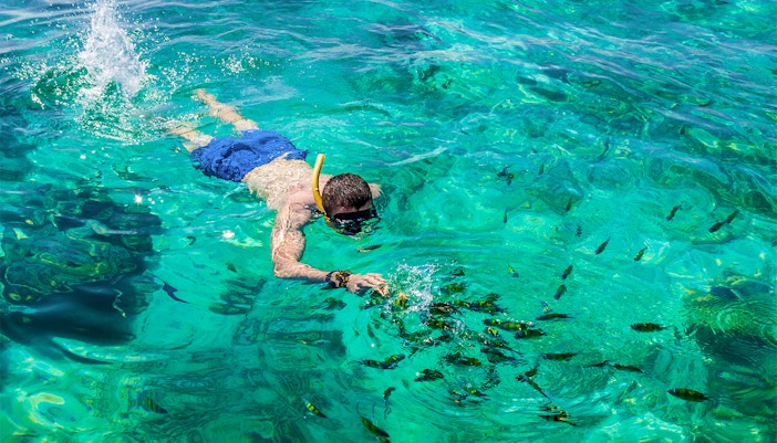 Man snorkeling in clear waters at Phi Phi Island, Phuket, Thailand.