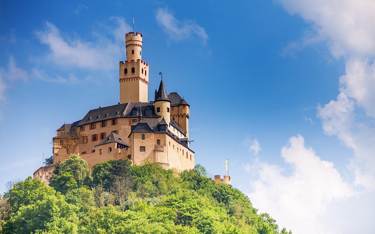 Marksburg Castle on a hilltop under a blue sky, Koblenz river cruise.