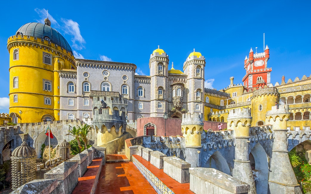 Pena Palace pathway with view of colorful castle towers in Sintra, Portugal.