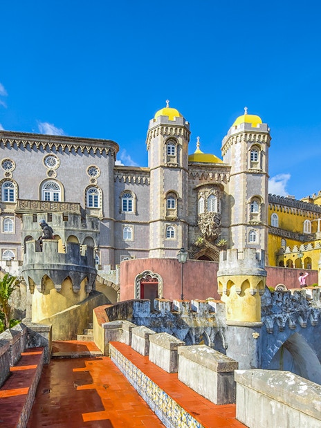 Pena Palace pathway with view of colorful castle towers in Sintra, Portugal.