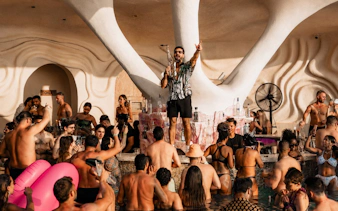 Crowd enjoying music and drinks at Luna Beach Club poolside event.