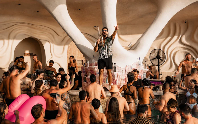 Crowd enjoying music and drinks at Luna Beach Club poolside event.