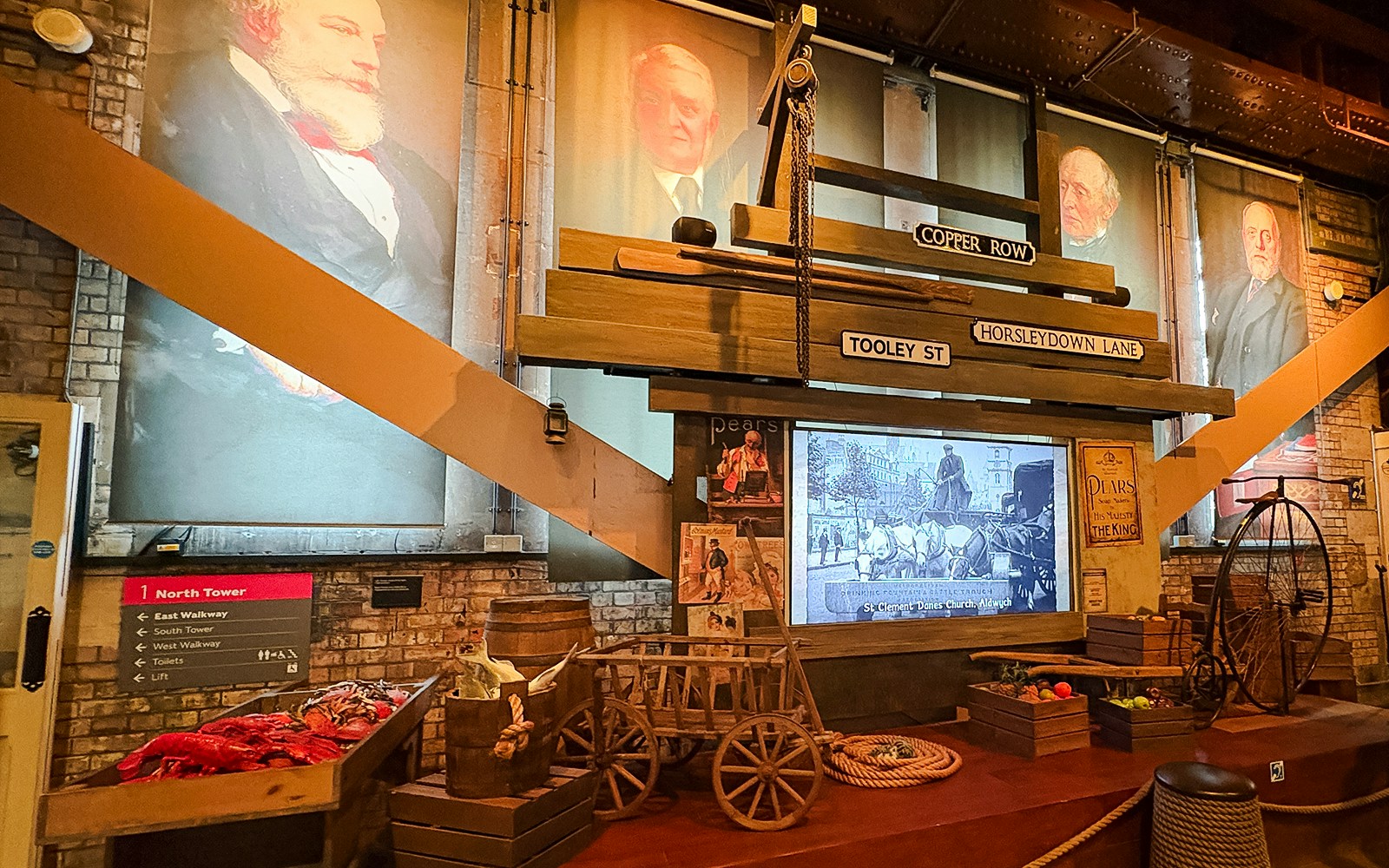 Modern exhibit at Tower Bridge London featuring historical street signs and vintage artifacts.
