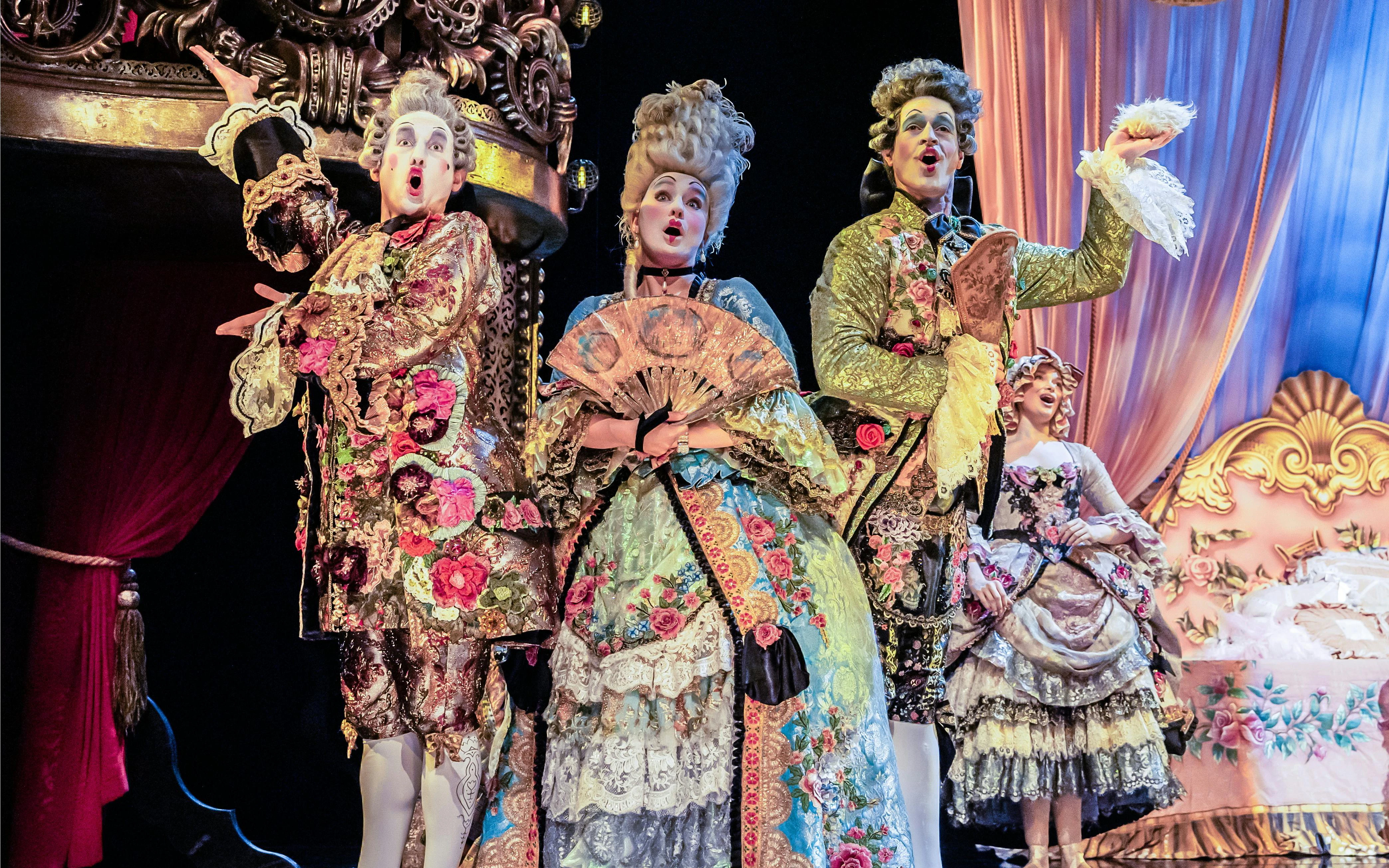 Performers in ornate costumes on stage during a Phantom production.